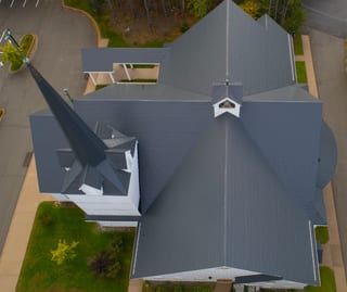 Deep Charcoal Interlock Slate aluminum roof on a church with a deep charcoal metal roof in a forested area, Rothesay, New Brunswick