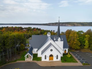 Deep Charcoal Interlock Slate aluminum roof on a white church among trees on a waterfront property, Rothesay, New Brunswick