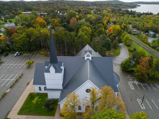 Deep Charcoal Interlock Slate aluminum roof on a church with a deep charcoal metal roof in a forested, Rothesay, New Brunswick
