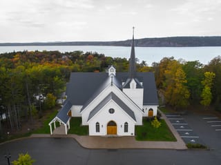 Deep Charcoal Interlock Slate aluminum roof on a white church with a metal roof among trees by the water, Rothesay, New Brunswick