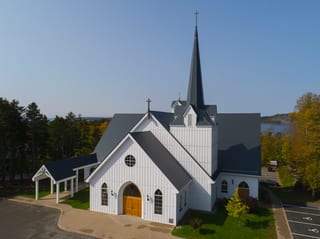 Deep Charcoal Interlock Slate aluminum roof on a white church with a black roof in a forested area, Rothesay, New Brunswick