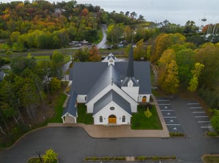 Deep Charcoal Interlock Slate aluminum roof on a white church with a metal roof in a forested area, Rothesay, New Brunswick