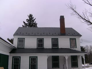 Charcoal Grey Interlock Slate aluminum roof on a white colonial home with a covered porch in a rural, Windham, New Hampshire