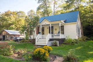 Royal Blue Interlock Slate aluminum roof on a single-family home with a blue metal roof in a forested, Lyme, New Hampshire