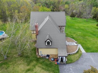 Deep Charcoal Interlock Slate aluminum roof on a colonial home with a grey roof in a forested setting, Madbury, New Hampshire