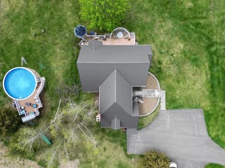 Deep Charcoal Interlock Slate aluminum roof on a grey two-storey colonial home with dormers on an acreage, Madbury, New Hampshire