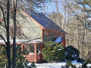 Deep Charcoal Interlock Slate aluminum roof on a two-storey home with dormers in a forested area, Wilmot, New Hampshire