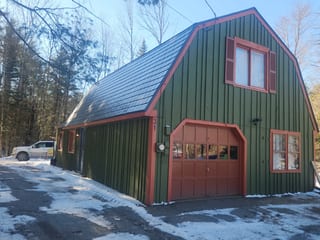 Deep Charcoal Interlock Slate aluminum roof on a green A-Frame home with a red door and shutters in the, Wilmot, New Hampshire