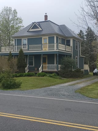 Black Interlock Slate aluminum roof on a two-storey Cape Cod home with dormers in a rural area, Riverport, Nova Scotia