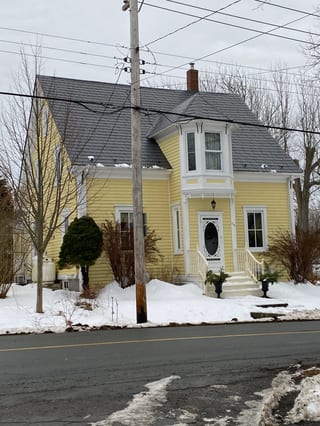 Charcoal Grey Interlock Slate aluminum roof on a yellow heritage home with a metal roof in Lunenburg, Nova, Lunenburg, Nova Scotia