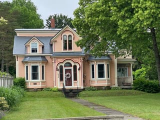 Charcoal Grey Interlock Slate aluminum roof on a peach two-storey Victorian home with dormers in a, Mahone Bay, Nova Scotia