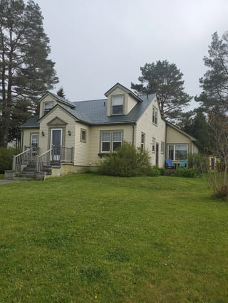 Hunter Green Interlock Slate aluminum roof on a two-storey cape cod home with a hunter green metal roof, Mahone Bay, Nova Scotia