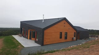 Deep Charcoal Interlock Standing Seam aluminum roof on a modern home with a black metal roof on a coastal rural, Cow Bay, Nova Scotia