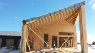 Deep Charcoal Interlock Standing Seam aluminum roof being installed on the home, Cow Bay, Nova Scotia