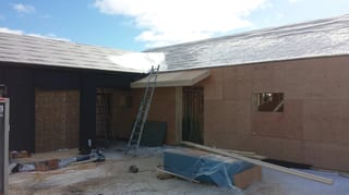 Deep Charcoal Interlock Standing Seam aluminum roof being installed on the home, replacing new construction, Cow Bay, Nova Scotia