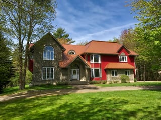 Black Interlock Slate aluminum roof on a red colonial home with a slate metal roof in a forested, Reids Hill (Shelburne), Nova Scotia