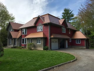 Black Interlock Slate aluminum roof on a red colonial home with dormers in a forested rural setting, Reids Hill (Shelburne), Nova Scotia