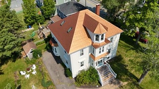Aged Copper Interlock Slate aluminum roof on a white two-storey home with a copper metal roof in a, Lunenburg, Nova Scotia