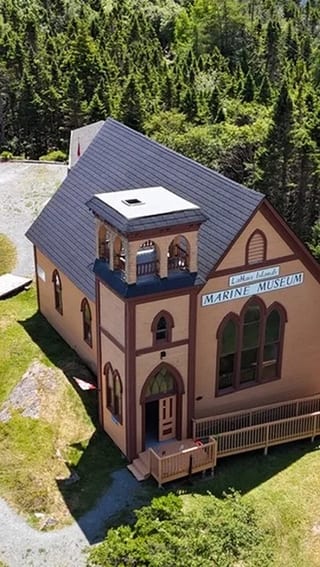 Black Interlock Slate aluminum roof on a church with a slate roof among trees by the ocean, Lahave, Nova Scotia
