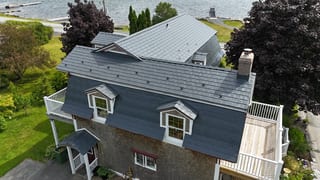 Deep Charcoal Interlock Slate aluminum roof on the home with roof louver and chimney, East LaHave, Nova Scotia