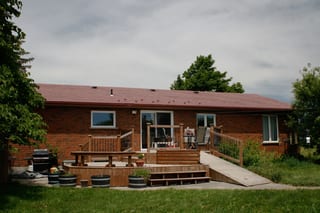Tile Red Interlock Shingle aluminum roof on a red brick ranch with a brown roof and front porch, Orangeville, Ontario