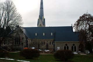 Charcoal Grey Interlock Slate aluminum roof on a tan brick church with a metal roof among trees in a rural, Owen Sound, Ontario