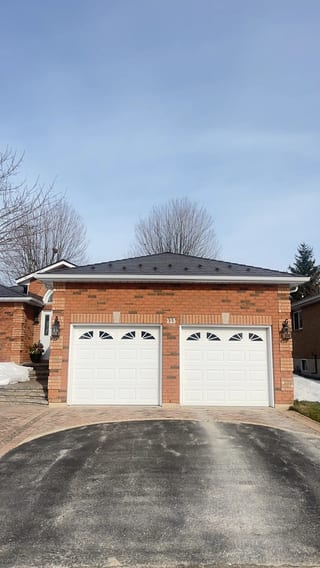 Tudor Brown Interlock Slate aluminum roof on a two-storey Tudor home with dormers in a suburban lakeside, Barrie, Ontario