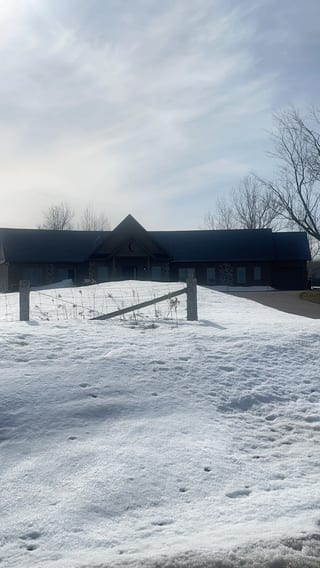 Deep Charcoal Interlock Slate aluminum roof on a black ranch-style home with a metal roof in a snowy rural, Springwater, Ontario