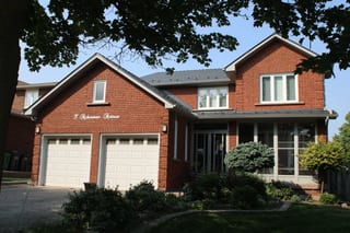 Deep Charcoal Interlock Cedar Shingle aluminum roof on a red brick two-storey home with dormers and a grey metal, Brampton, Ontario