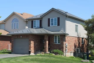 Musket Grey Interlock Cedar Shingle aluminum roof on a grey two-storey home with a metal roof in a suburban, Guelph, Ontario