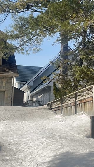 Deep Charcoal Interlock Slate aluminum roof on a grey single-family home with a metal roof in a suburban, Wasaga Beach, Ontario