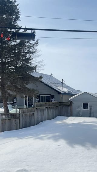Deep Charcoal Interlock Slate aluminum roof on a grey single-family home with a metal roof in a snowy, Ramara, Ontario