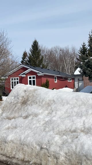 Black Interlock Slate aluminum roof on a red one-storey ranch home with a black metal roof in a, Orillia, Ontario