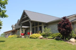 Musket Grey Interlock Cedar Shingle aluminum roof on a beige ranch with a metal roof surrounded by lush greenery, Guelph, Ontario