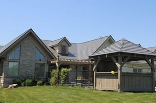 Musket Grey Interlock Cedar Shingle aluminum roof on a grey house with a metal roof on a rural road, Guelph, Ontario