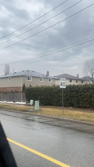 Tudor Brown Interlock Slate aluminum roof being installed on a two-storey home with brick accents in a suburban, Burlington, Ontario