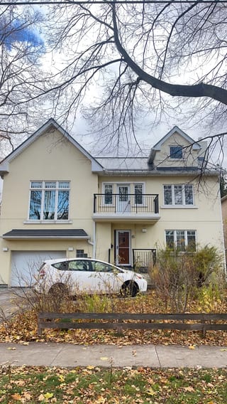 Front elevation of a 2-storey modern home in Etobicoke with deep charcoal standing seam metal roofing, dormers, and a second-floor balcony.