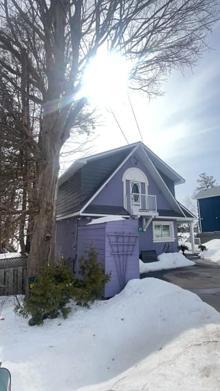 Musket Grey Interlock Cedar Shingle aluminum roof on a grey two-storey cottage with a metal roof among evergreen, Severn, Ontario
