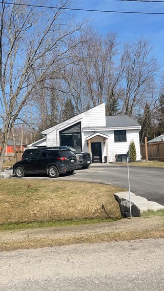 Deep Charcoal Interlock Slate aluminum roof on a white single-family home with a metal roof among trees, Belle Ewart, Ontario