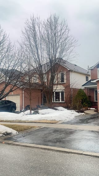 Two-storey brick Colonial home in Burlington ON with Interlock Cedar Shingle metal roof in Colonial Brown, viewed from across the street in winter.