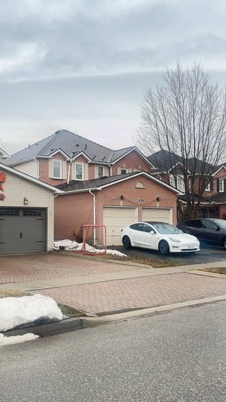 Two-storey suburban brick home in Burlington ON with Interlock Colonial Brown cedar shingle metal roof featuring multi-hip complex roofline and dormers.