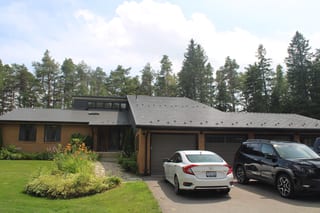 Musket Grey Interlock Cedar Shingle aluminum roof on a house with a garage and a white car in front of a forest, Mono, Ontario