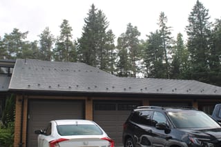 Musket Grey Interlock Cedar Shingle aluminum roof on a two-storey modern home with a metal roof among tall trees, Mono, Ontario