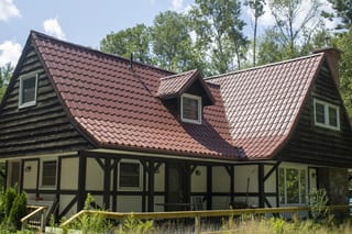 Tile Red Interlock Tile aluminum roof on a cottage with a red metal roof in a forested lakeside, Gravenhurst, Ontario