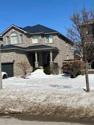 Deep Charcoal Interlock Slate aluminum roof on a beige two-storey home with a metal roof in a suburban, Barrie, Ontario