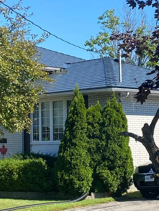 Deep Charcoal Interlock Slate aluminum roof on a white brick ranch-style home with a metal roof among, Belleville, Ontario