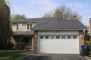 Two-storey Colonial-style home in Mississauga with Interlock aluminum cedar-shingle metal roofing in Colonial Brown, featuring snow guards and a brick chimney.