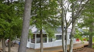 Deep Charcoal Interlock Cedar Shingle aluminum roof on a white cottage with a metal roof and a large deck, Winderemere, Ontario