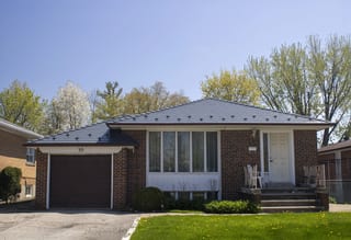 Ranch-style brick bungalow in North York with a deep charcoal Interlock aluminum slate hip roof, single garage, and front entry steps.