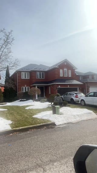 Black Interlock Slate aluminum roof on a red brick home with a two-car garage in a suburban, Mississauga, Ontario